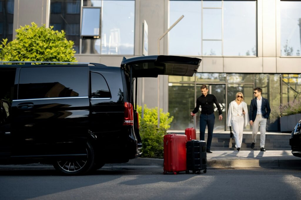 Driver helps a business couple carry their suitcases to the car from a hotel